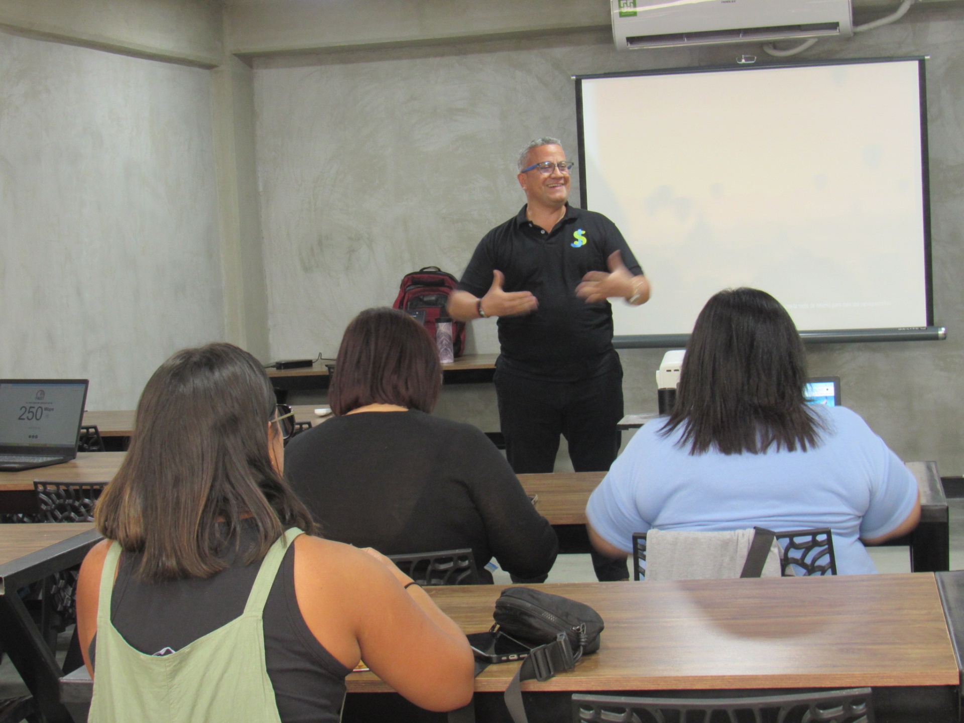 Instructor dictando una clase frente a participantes en WORKLAB